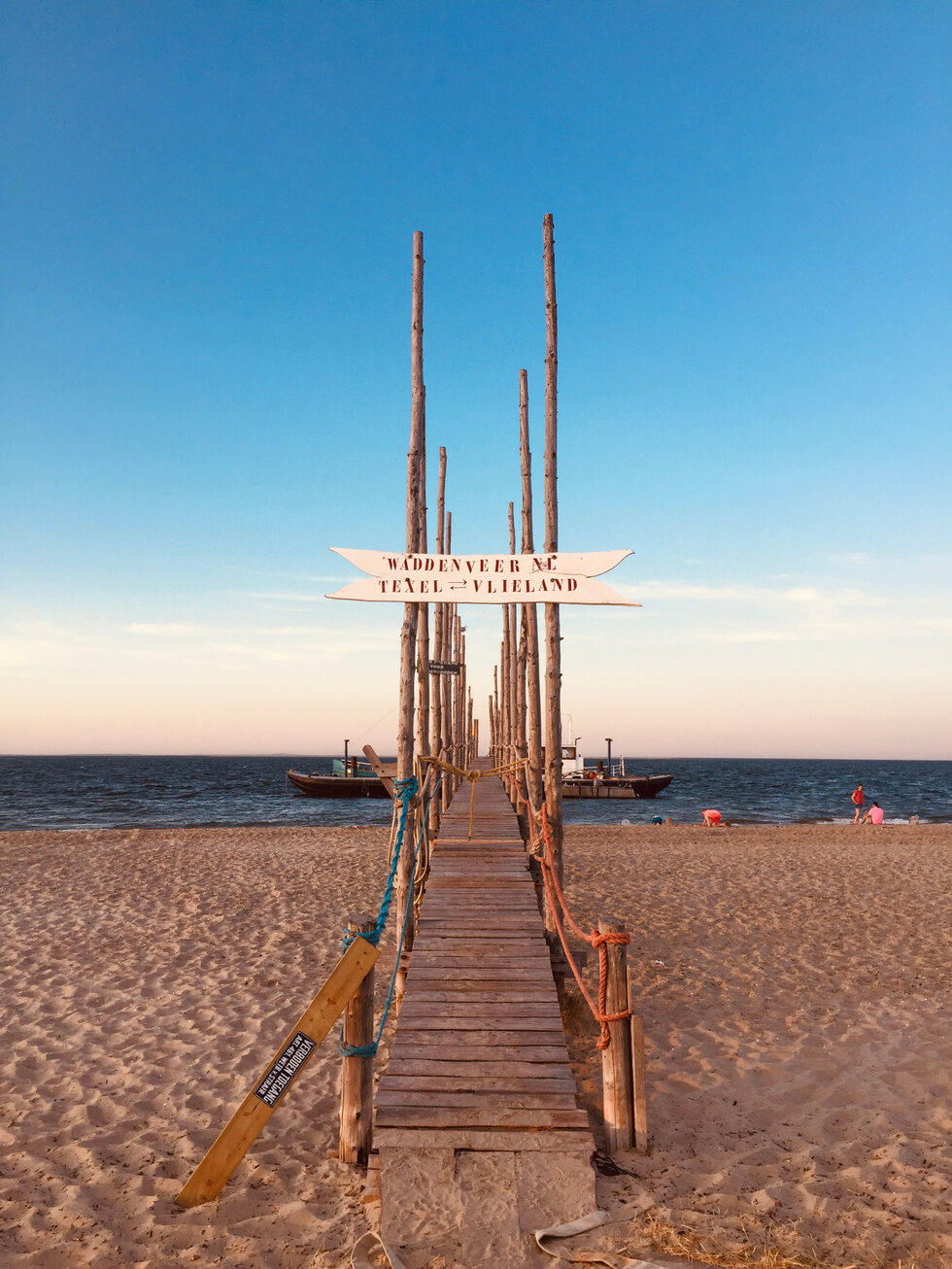 Wadden­veer steiger op het strand met palen en touwen.